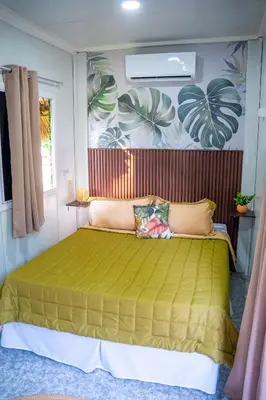 a bedroom with a bed with a green bedspread at Eco Suites El Zonte in La Libertad