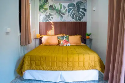 a bedroom with a bed with a yellow bedspread at Eco Suites El Zonte in La Libertad