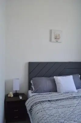 a bedroom with a bed and a night stand with a lamp at sophia by aby House in San Miguel