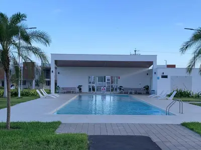 a swimming pool with chairs in front of a building at sophia by aby House in San Miguel