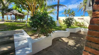 a white bench in a yard with palm trees at Casita d Playa 1 in La Esmeralda