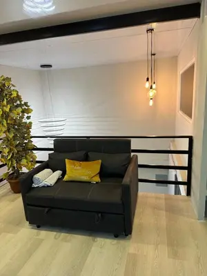 a black couch in a living room with a wall at Moderno & acogedor Apartmento, 2 habitaciones , 4 camas in Concepción de Ataco