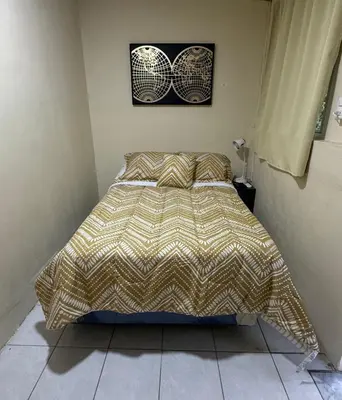 a bed with a comforter in a bedroom at Copinol 68 in San Salvador