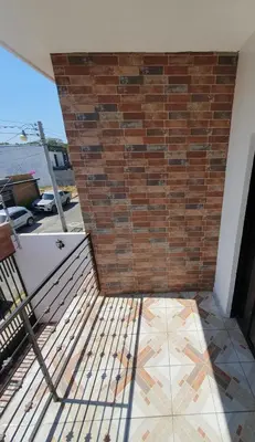 a balcony with a brick wall and a tile floor at Altagracia Altagracia in Santa Ana