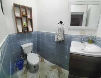 a bathroom with a toilet and a sink at Altagracia Altagracia in Santa Ana
