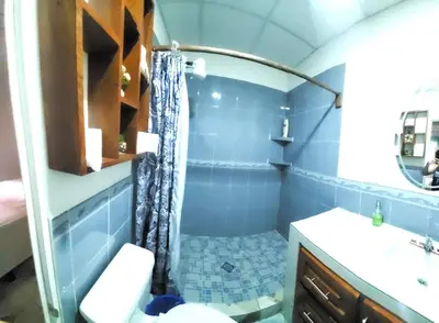 a blue bathroom with a shower and a sink at Altagracia Altagracia in Santa Ana