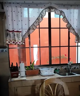 a kitchen counter with a window and a sink at Altagracia Altagracia in Santa Ana