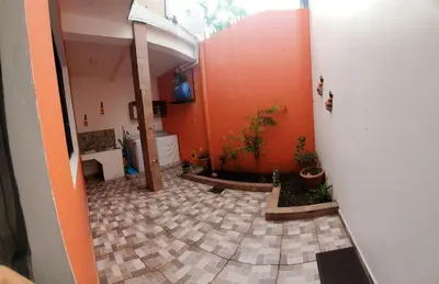 a hallway with orange walls and a tile floor at Altagracia Altagracia in Santa Ana