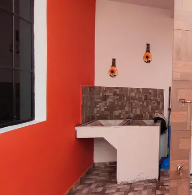 a kitchen with a white counter and red wall at Altagracia Altagracia in Santa Ana