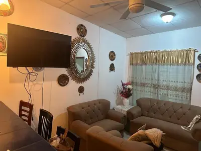 a living room with a couch and a flat screen tv at Casa de tres Unique Welcoming Familiar in San Miguel