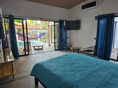 a bedroom with a bed and a sliding glass door at Wayo ocean view Tamanique house in Tamanique