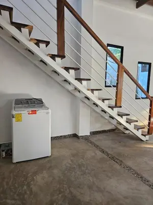 an empty room with a staircase and a refrigerator at Wayo ocean view Tamanique house in Tamanique