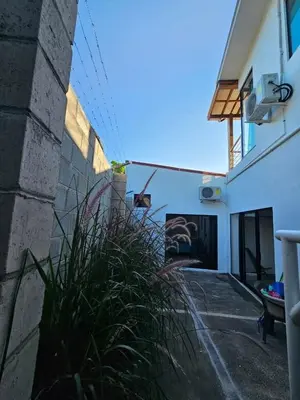 a building with a plant next to a wall at Wayo ocean view Tamanique house in Tamanique