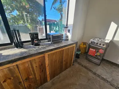 a kitchen with a counter with a stove and a window at Wayo ocean view Tamanique house in Tamanique