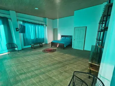 a blue room with a bed and a chair at Wayo ocean view Tamanique house in Tamanique