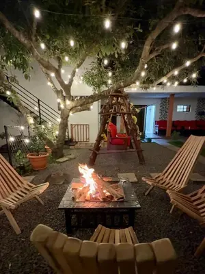 a fire pit in a backyard with chairs and a tree at SimpleSerenity Country House in Juayúa