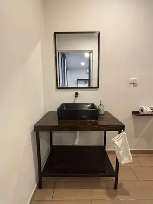 a bathroom with a black sink and a mirror at SunSal Garden Surf Hub in El Sunzal