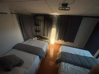 a room with two beds and a lamp in it at SunSal Garden Surf Hub in El Sunzal