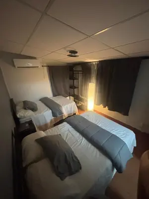 a bedroom with two beds and a light on the wall at SunSal Garden Surf Hub in El Sunzal