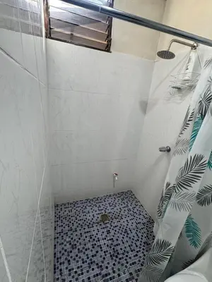 a bathroom with a shower with a black and white tile floor at Cozy house in the center of San Vicente in San Vicente