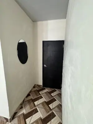 a hallway with a black door and a tiled floor at Cozy house in the center of San Vicente in San Vicente