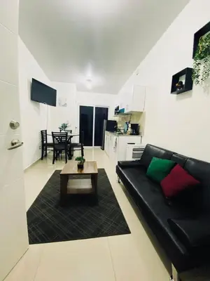 a living room with a black couch and a table at VillaOriental in San Miguel