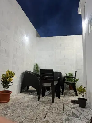 a patio with a table and chairs in front of a wall at VillaOriental in San Miguel