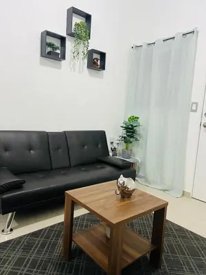 a living room with a black couch and a coffee table at VillaOriental in San Miguel