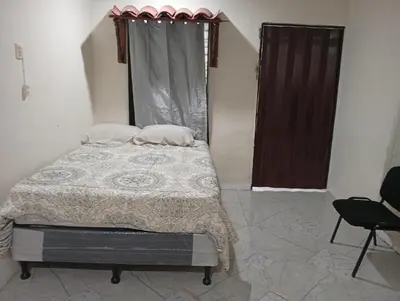 a bedroom with a bed with two pillows on it at Casa de Mario in Santa Ana