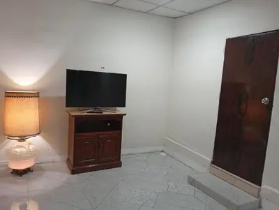 a television on a stand in a room with a lamp at Casa de Mario in Santa Ana