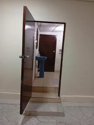 a door to a bathroom with a toilet in a hallway at Casa de Mario in Santa Ana