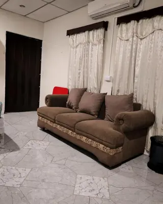 a brown couch sitting in a room with curtains at Casa de Mario in Santa Ana