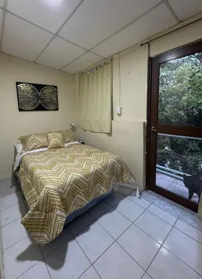 a bedroom with a bed and a window at Copinol 68 in San Salvador