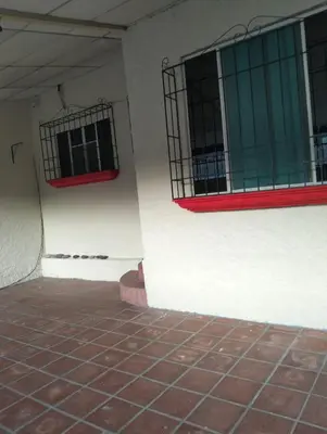 a corner of a building with two windows and a brick floor at Copinol 68 in San Salvador
