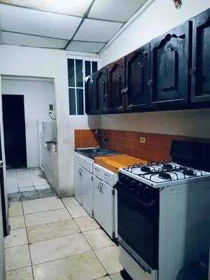 a kitchen with black cabinets and a stove at Copinol 68 in San Salvador