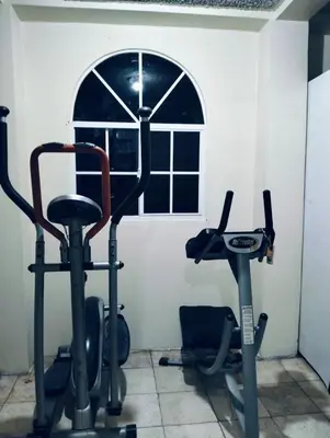 a gym with two exercise bikes and a window at Copinol 68 in San Salvador