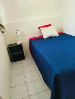 a bedroom with a blue bed with a white pillow at Copinol 68 in San Salvador
