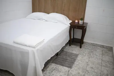 a bedroom with a white bed and a night stand at Cowboys Home in Juayúa
