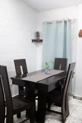 a black dining room table with chairs and a blue curtain at Cowboys Home in Juayúa