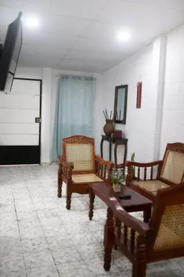 a living room with wooden chairs and a table at Cowboys Home in Juayúa