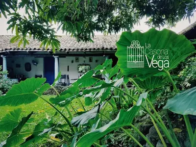 a garden with a building in the background at Casona los Vega in Izalco