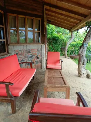 a porch with two red chairs and a table at cabaña Lechuza café in Juayúa