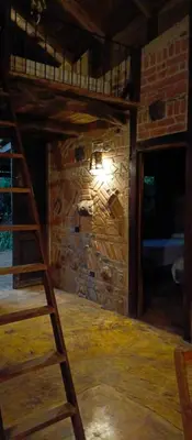 a room with two bunk beds and a ladder at cabaña Lechuza café in Juayúa