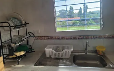 a kitchen sink with a drying rack next to a window at Mi pueblo Hostal Nahuizalco in Nahuizalco