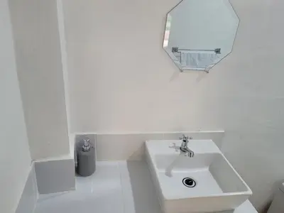 a white bathroom with a sink and a mirror at Mi pueblo Hostal Nahuizalco in Nahuizalco