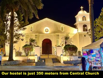 a building with a church with a clock on it at Mi pueblo Hostal Nahuizalco in Nahuizalco