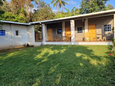 a house with a lawn in front of it at Mi pueblo Hostal Nahuizalco in Nahuizalco