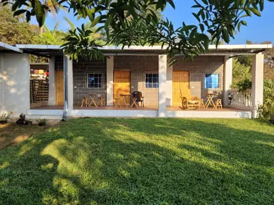 a house with a lawn in front of it at Mi pueblo Hostal Nahuizalco in Nahuizalco