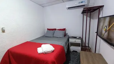 a small room with a bed with a red blanket at Studio Suite 3, Buena Vista, Santa Tecla in Nueva San Salvador