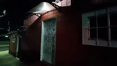 a door on the side of a red brick building at night at Studio Suite 3, Buena Vista, Santa Tecla in Nueva San Salvador